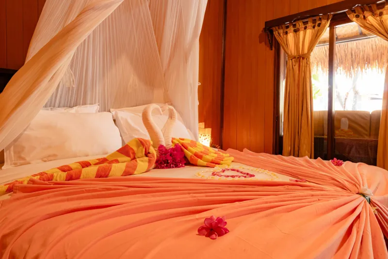 Romantic bed styling with towel swans and petals