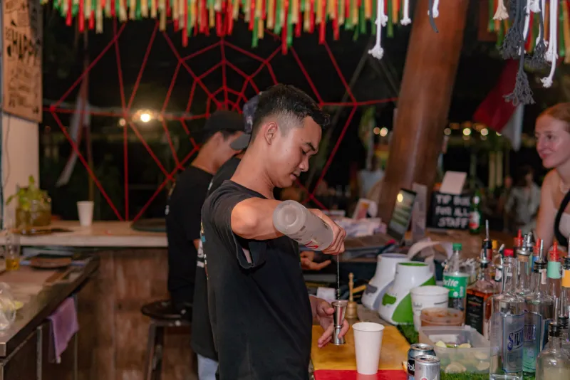 Bartender mixing cocktails at Raja Bar at night