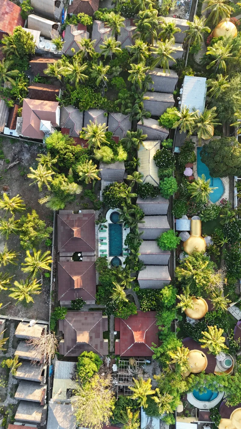 Aerial view over resort rooftops and greenery