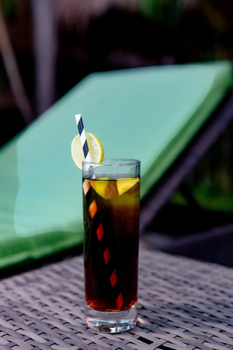 Eisgekühlter Rum-Cola mit einer Limettenscheibe