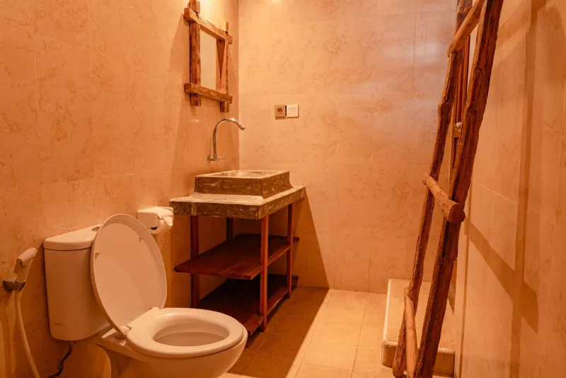 Kamar mandi berubin dengan wastafel batu dan toilet