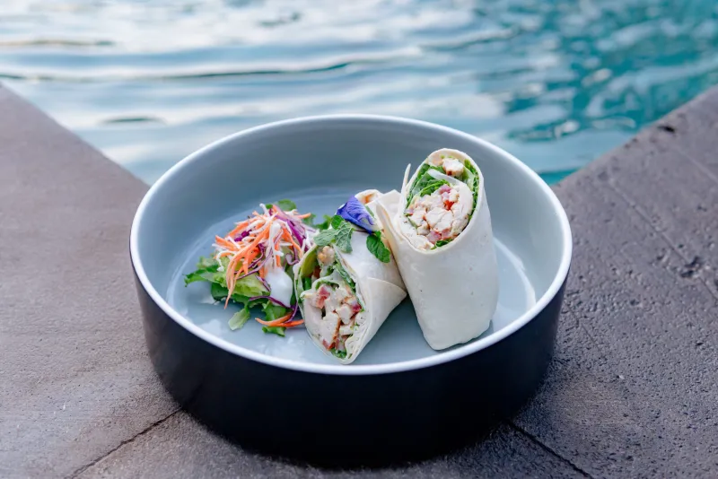 Kipwrap en salade geserveerd bij het zwembad